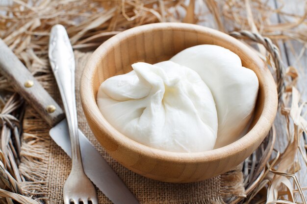 Burrata de queijo italiano fechada em uma tigela com garfo e faca