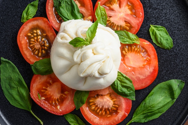 Burrata-Käse serviert mit frischen Tomaten und Basilikumblättern