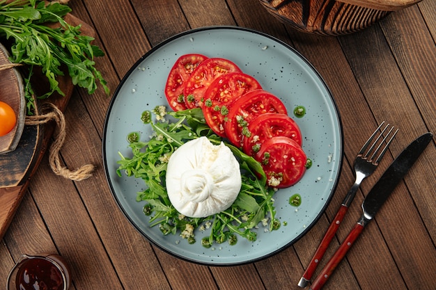 Burrata-Käse-Tomaten und grüner Salat