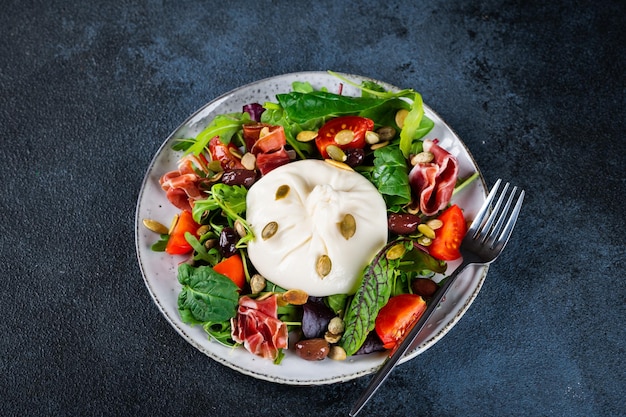 Burrata Queso fresco italiano hecho con crema y leche de búfalo o vaca Ensalada de burrata con tomates y mezcla de ensalada Concepto de alimentación saludable Ensalada de dieta Keto