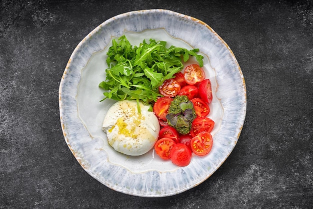 Burrata con tomates cherry de rúcula y salsa pesto