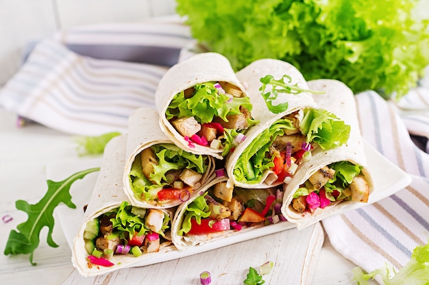 Burrito de galinha. Almoço saudável. Tortilha de fajita de comida de rua mexicana envolve filé de frango grelhado e legumes frescos.