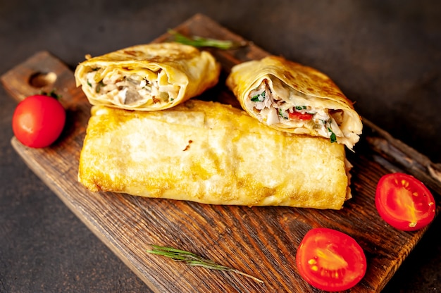 Burrito envuelto con pollo y verduras, sobre un fondo de hormigón, shawarma mexicano