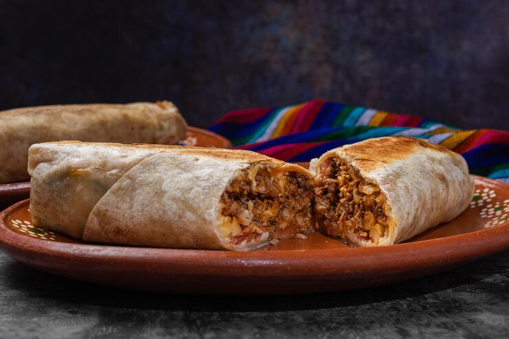 Foto burrito mexicano cortado en un plato de arcilla comida rápida mexicana
