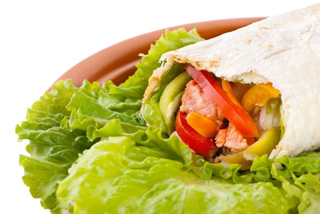 Burrito mit Lachs, gelber, grüner und roter Paprika und Tomate auf Teller