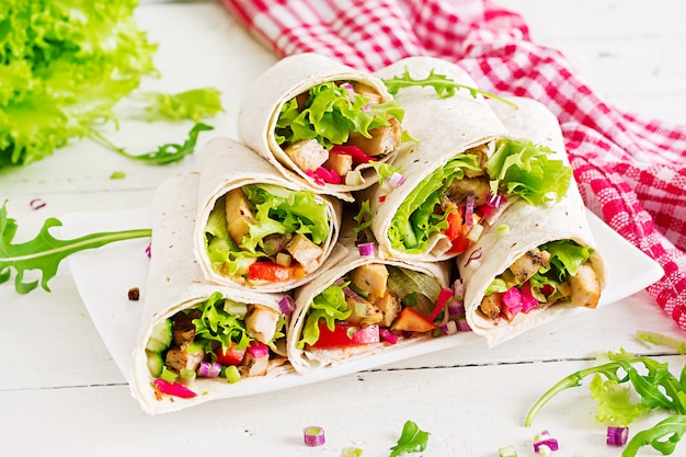 Burrito de pollo. Comida saludable. Tortilla de fajita mexicana de comida callejera envuelta con filete de pollo a la parrilla y verduras frescas.