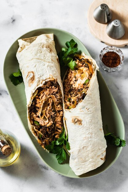 Burrito con salmón frito y verduras en una mesa de mármol cocina mexicana