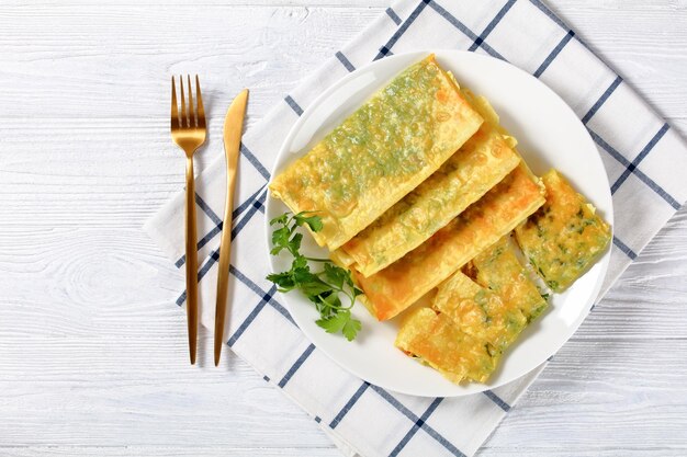 Burritos con limaduras de queso y verduras en un plato