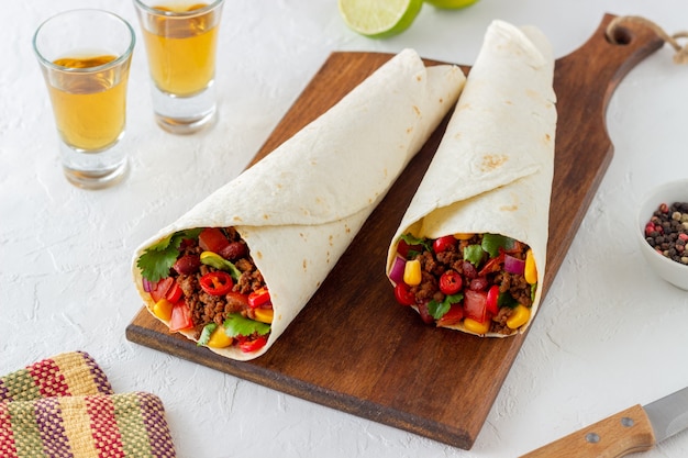 Burritos mit Fleisch, Bohnen, Mais, Tomaten, Zwiebeln und Chili. Mexikanische Nahrung. Rezept.