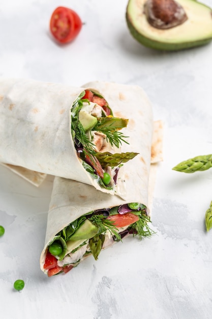 Burritos mit gebratenem Hühnerfleisch und Gemüsespargel, Avocado, Tomaten, Erbsen, Käse und Tatar