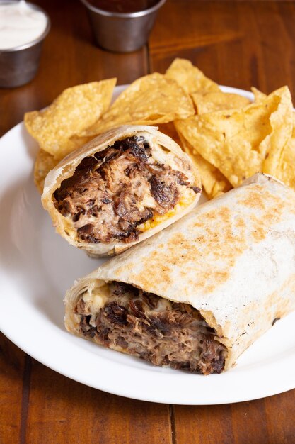 Foto burritos rellenos de carne con nachos con salsas