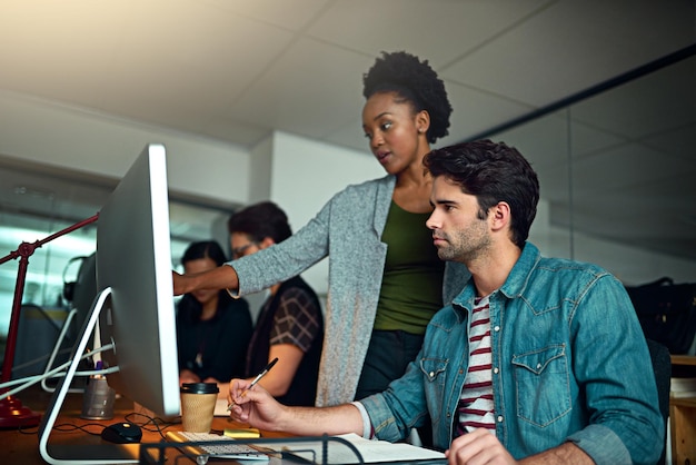 Buscando un consejo Captura recortada de dos jóvenes diseñadores trabajando en la oficina