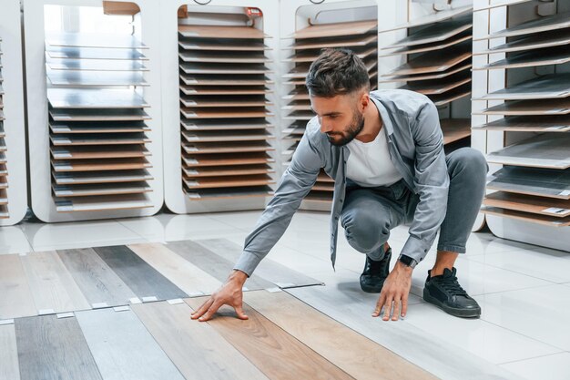 Buscando parquet Un hombre hermoso y elegante está en la tienda de artículos para el hogar