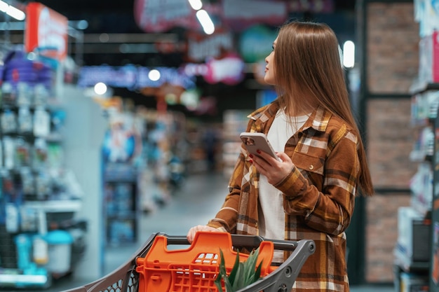 Buscando productos Una mujer está haciendo compras en el supermercado