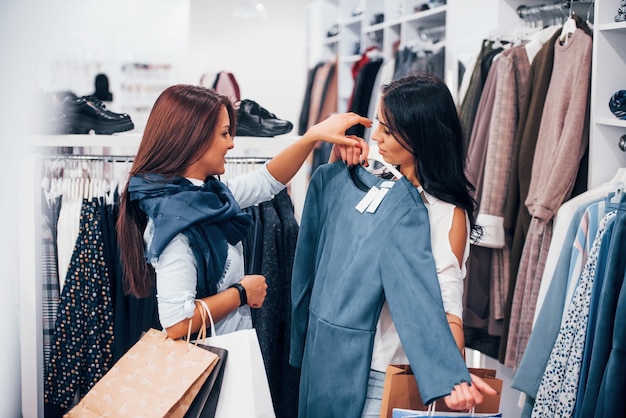 Buscando ropa de abrigo. Dos mujeres jóvenes tienen un día de compras juntas en el supermercado.