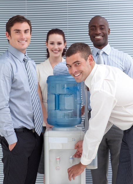 Foto busines personas de pie alrededor de enfriador de agua