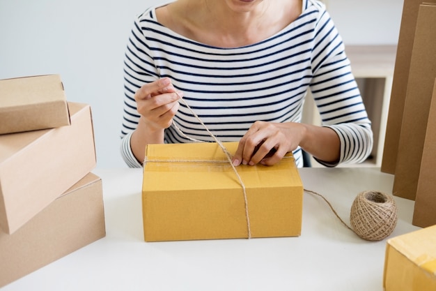 Business-Besitzer Frau arbeiten Online-Shopping vorbereiten Produkt Verpackung Prozess bei ihr zu Hause, junge Unternehmer-Konzept.