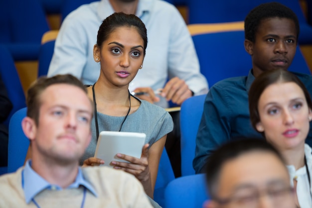 Business Executive, der an einem Geschäftstreffen teilnimmt und sich im Konferenzzentrum Notizen macht