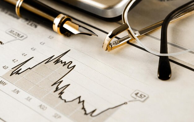 Business-Hintergrund. Betriebswirtschaftlicher Hintergrund mit Grafiken, Gläsern, Stift und Taschenrechner.