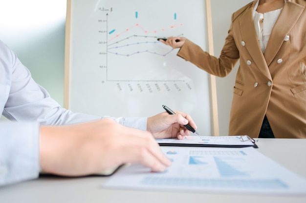 Business-Kollegen Brainstorming diskutieren Umsatz Wert Leistung auf White Board während Präsentation in modernen Büro-Raum