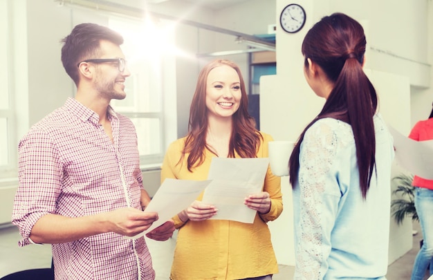 Foto business-, kommunikations-, start-up- und people-konzept – glückliches multiethnisches kreativteam oder studenten in der kaffeepause, die sich im büro unterhalten