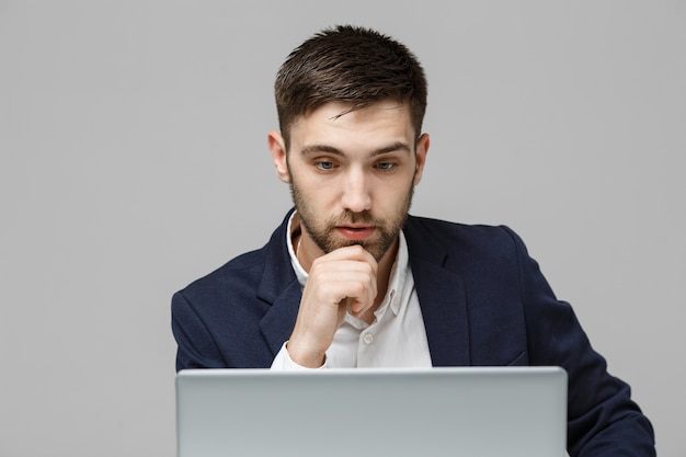 Business-Konzept - Porträt hübscher stressigen Geschäftsmann in Anzug Schock suchen vor Laptop am Arbeitsplatz Büro. Weißer Hintergrund.