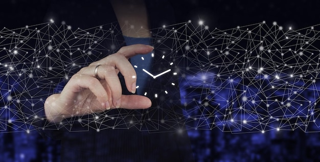 Business Life Time Passing Management Business Plans Konzept Digitales Hologramm-Uhrzeichen in der Hand halten auf dunklem, verschwommenem Hintergrund der Stadt