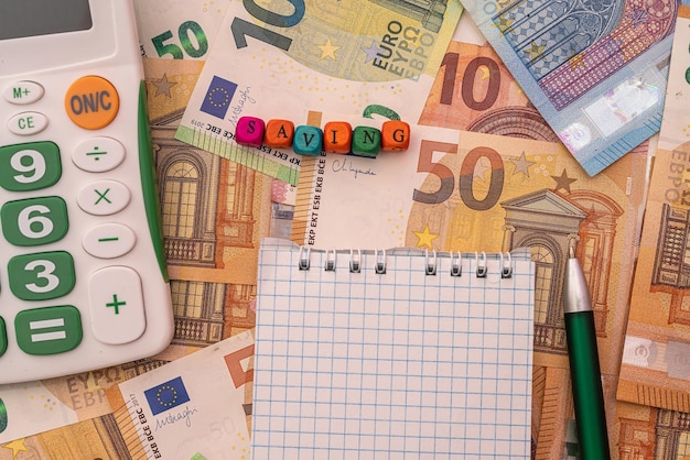 Business-Notebook mit Stift-Rechner liegen auf Hintergrund mit Euro-Banknoten Geschäftskonzept