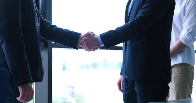 Business Partner Shake Hands on meetinig en el moderno edificio de oficinas