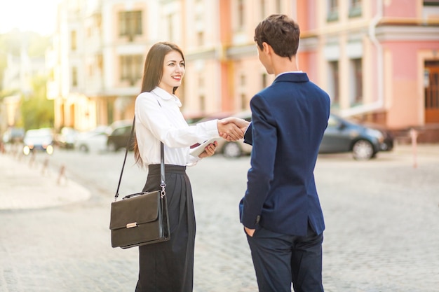 Business-partnerschaft-technologie und people-konzept lächelnder geschäftsmann und geschäftsfrauen-handshake