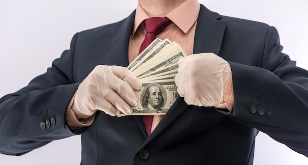 Business-Person Hand in blauen Schutzhandschuhen mit Geld isoliert auf weißem Hintergrund. Save Protect Konzept Covid 19 Coronavirus