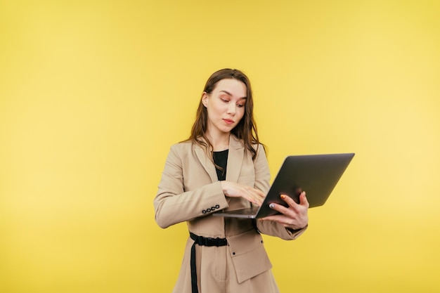 Business schöne Frau mit Laptop isoliert auf einem farbigen Hintergrund