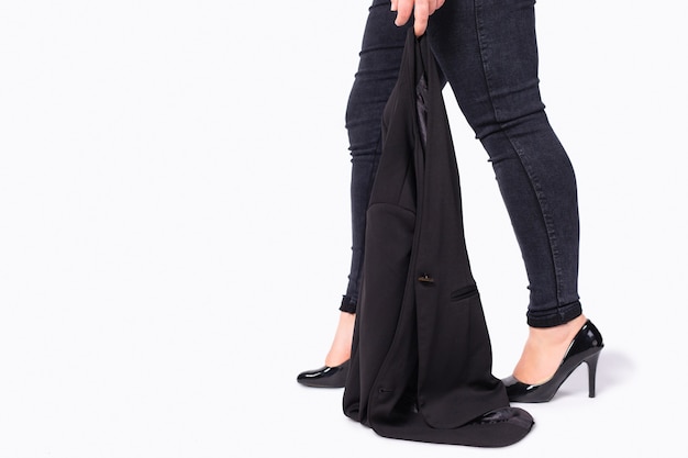 Business-Style-Outfit beschnittenes Foto von weiblichen Übergewichtigen plus Größenfüßen, die hochhackige Schuhe tragen, die Jacke mit hohen Absätzen schwarze Schuhe auf grauem Hintergrund mit leerem Platz für Werbung tragen