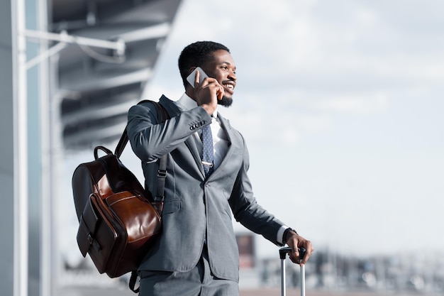 Business Talk hombre africano hablando por teléfono en el aeropuerto