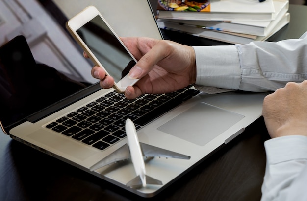 Business Traveler usando su teléfono para reservar vuelo.