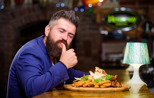 Businessman formellen Anzug sitzen im Restaurant Mann erhielt Mahlzeit mit gebratenen Kartoffeln Fischstäbchen Fleisch Er verdient köstliche Mahlzeit Genießen Sie Ihre Mahlzeit Kalorienreiche Snacks Leckeres Essen Entspannen Sie sich nach einem anstrengenden Tag