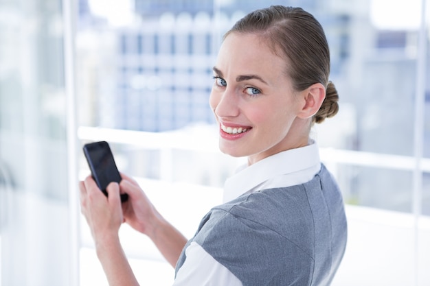 Businesswomen texting com seu smartphone