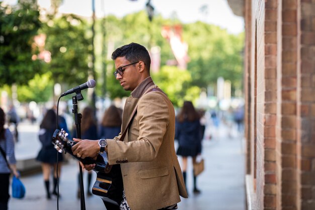 Busker bereitet seine Gitarre vor, bevor er auf der Straße spielt