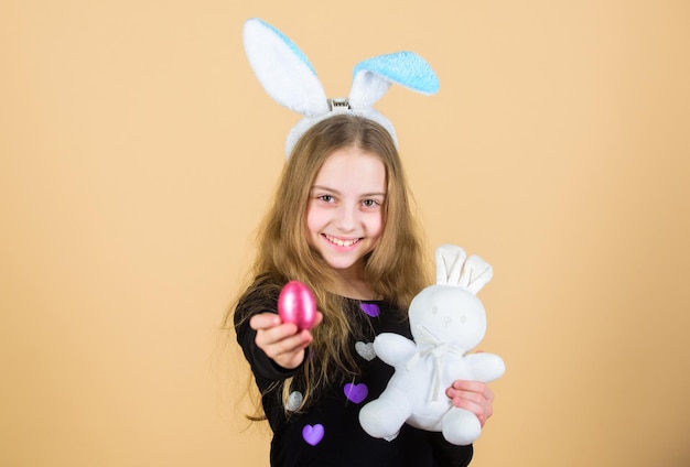 Búsqueda de huevos de Pascua como parte del festival Origen del conejito de Pascua Símbolos y tradiciones de Pascua Niño juguetón con peluche Conoce las vacaciones de primavera Niña niño pequeño accesorio de conejito de Pascua sujetar huevo teñido