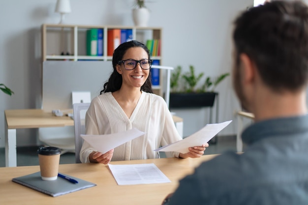 Búsqueda de trabajo gerente de recursos humanos hablando con el solicitante de empleo en la celebración de una entrevista de trabajo