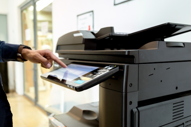 Bussiness man Handpresseknopf auf Platte des Druckers, Druckerscannerlaser-Bürokopie-Maschinenversorgungen beginnen Konzept.