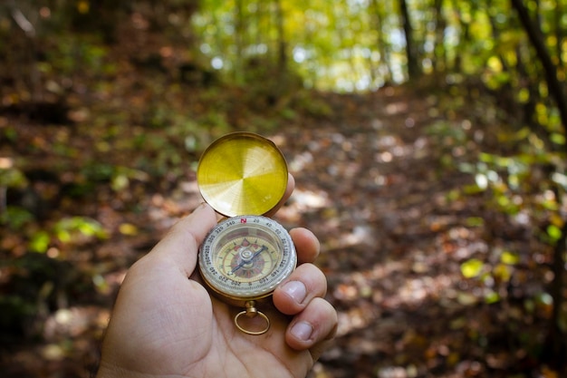 Bússola na mão na floresta de outono