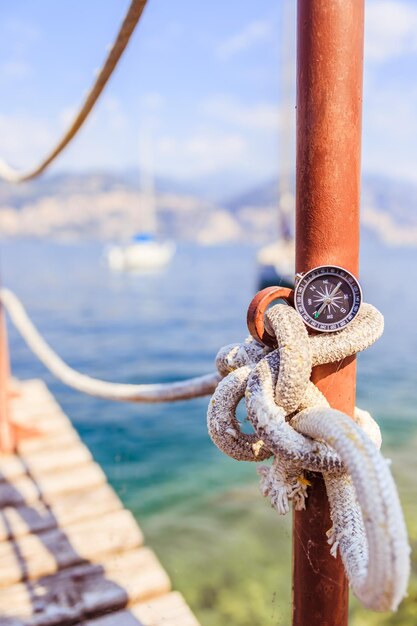 Bússola náutica à vela em um píer de corda à vela Barcos à vela ao fundo