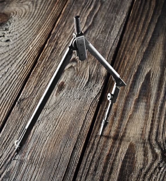 Bússolas de metal em uma mesa de madeira.