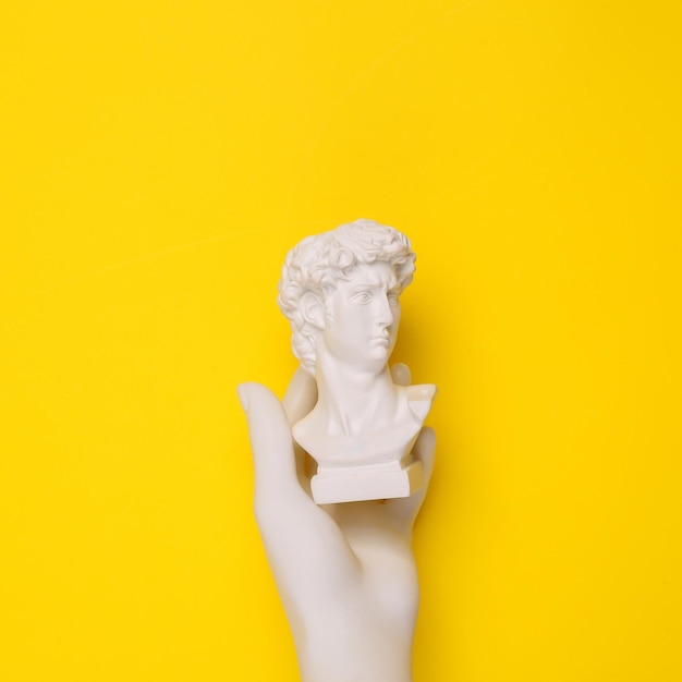 Busto de David con la mano en el fondo amarillo Naturaleza muerta minimalista