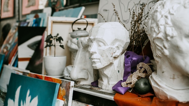 Busto de escultura y herramientas en un taller de arte de fondo