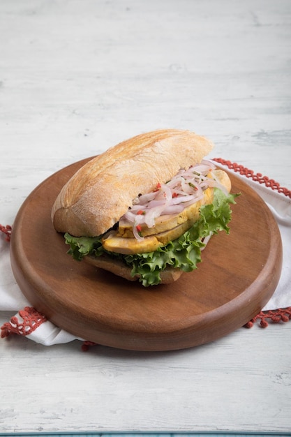 Butifarra sándwich tradicional de peurvian con lechuga de jamón de cerdo y cebolla en tabla de madera