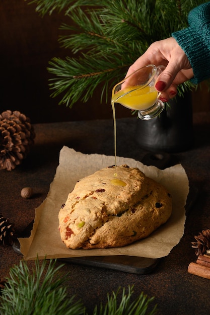 Butter auf Christstollen gießen Nahaufnahme