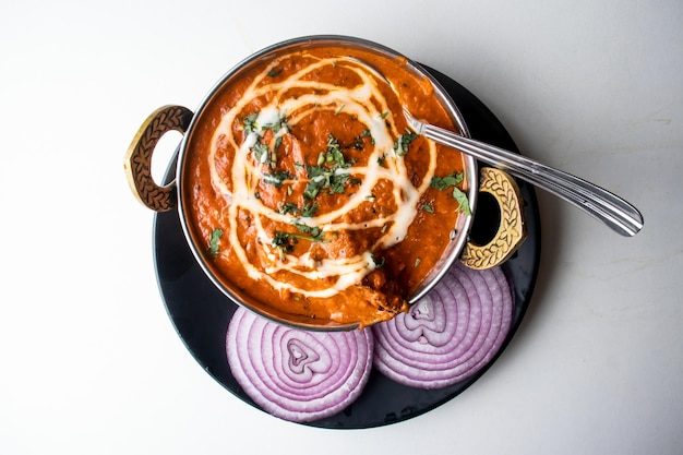 Butter Chicken Karahi oder Chicken Makhni mit Zwiebeln und Chili serviert in einem Gericht isoliert auf grauem Hintergrund Draufsicht auf bangladeschisches Essen