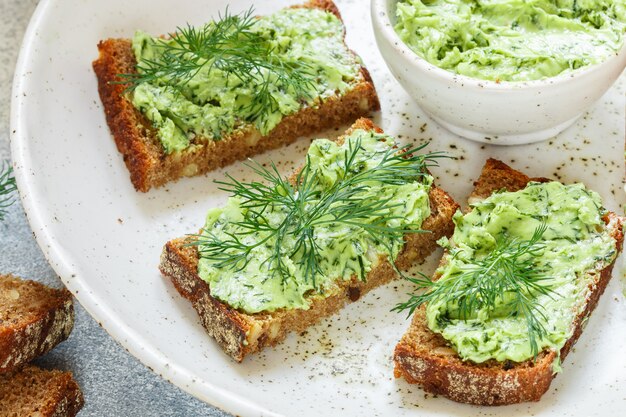 Butter mit Dill auf Roggenbrot mit Sonnenblumenkernen